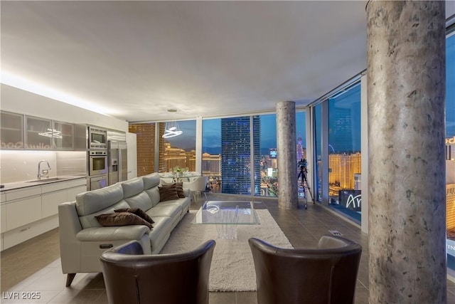 tiled living area featuring expansive windows and a sink