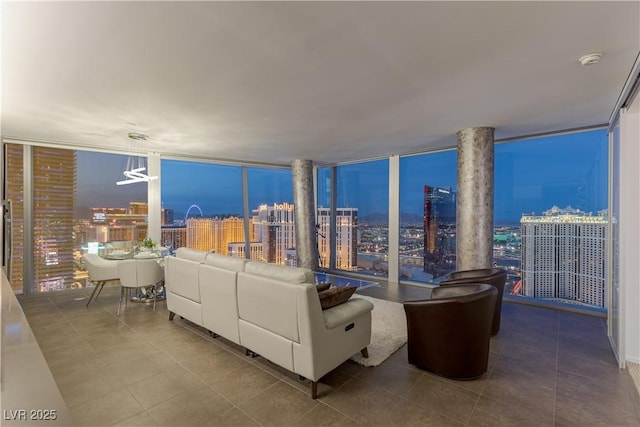 living room with expansive windows, a view of city, and tile patterned flooring