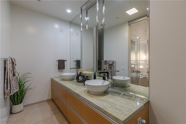 bathroom with double vanity, recessed lighting, and a sink