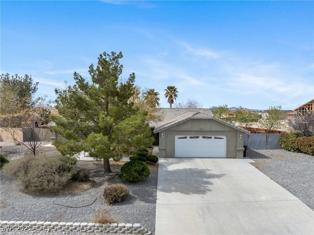 view of front of home featuring concrete driveway, stucco siding, fence, an attached garage, and a tiled roof