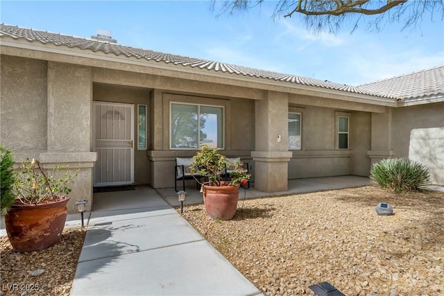 entrance to property featuring stucco siding