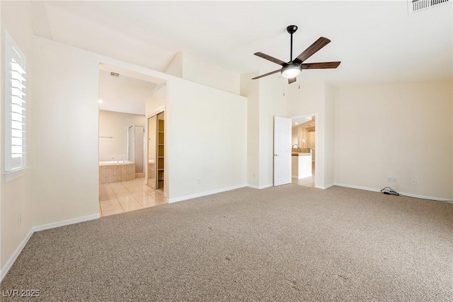 tiled spare room with baseboards, carpet floors, visible vents, and a ceiling fan