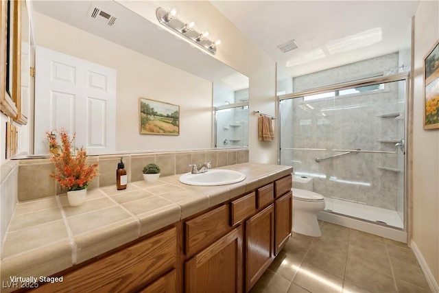bathroom featuring vanity, toilet, a shower stall, tile patterned floors, and visible vents