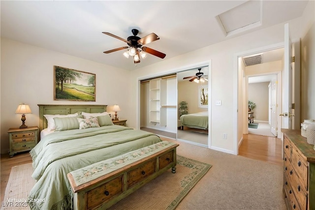 bedroom with attic access, light carpet, baseboards, visible vents, and ceiling fan