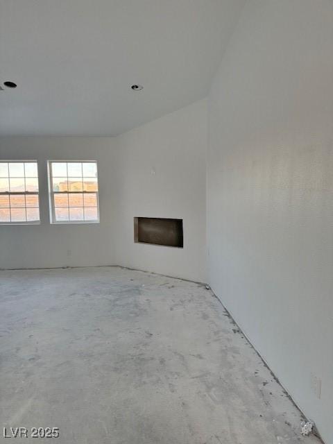 unfurnished living room featuring a fireplace and concrete flooring