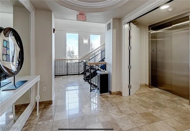 hallway featuring baseboards, visible vents, and elevator