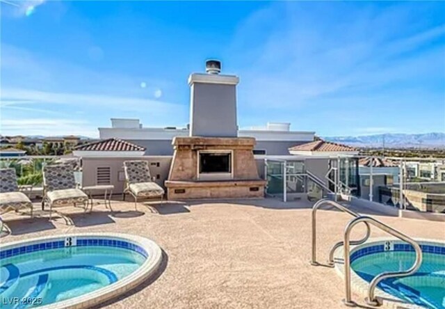 view of pool featuring a community hot tub, exterior fireplace, and a patio area