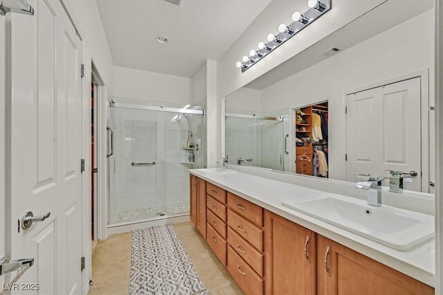 7741 Fruit Dove St, North Las Vegas, NV 89084 - full bath featuring a shower stall, double vanity, tile patterned flooring, and a walk in closet