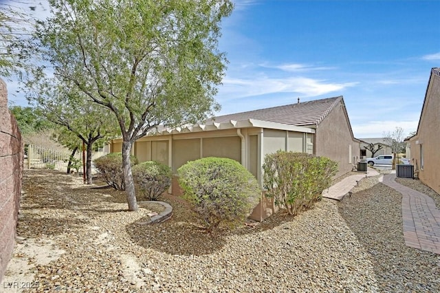 7741 Fruit Dove St, North Las Vegas, NV 89084 - view of property exterior featuring cooling unit, stucco siding, and a tile roof