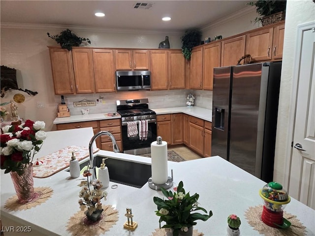 7741 Fruit Dove St, North Las Vegas, NV 89084 - kitchen with stainless steel appliances, light countertops, decorative backsplash, brown cabinets, and crown molding
