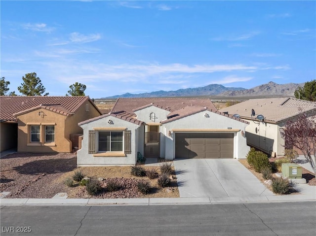 view of front of house featuring a tile roof, stucco siding, an attached garage, driveway, and a mountain view