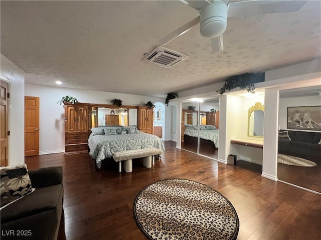 4861 Pahrump Valley Blvd, Pahrump, NV 89048 - bedroom featuring a textured ceiling, visible vents, two closets, baseboards, and wood finished floors
