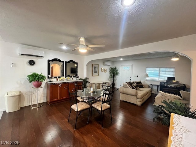 4861 Pahrump Valley Blvd, Pahrump, NV 89048 - dining space featuring arched walkways, a wall mounted AC, dark wood-type flooring, and a ceiling fan