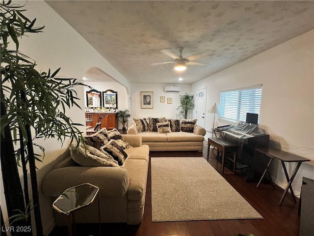 4861 Pahrump Valley Blvd, Pahrump, NV 89048 - living area featuring arched walkways, dark wood-style floors, an AC wall unit, and a ceiling fan
