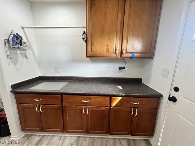4861 Pahrump Valley Blvd, Pahrump, NV 89048 - kitchen with light wood finished floors, brown cabinets, and dark countertops