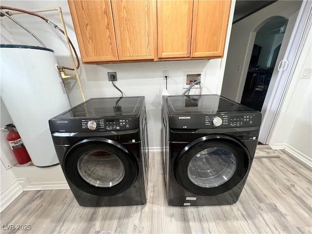 4861 Pahrump Valley Blvd, Pahrump, NV 89048 - laundry room with baseboards, washing machine and clothes dryer, cabinet space, and light wood-style floors