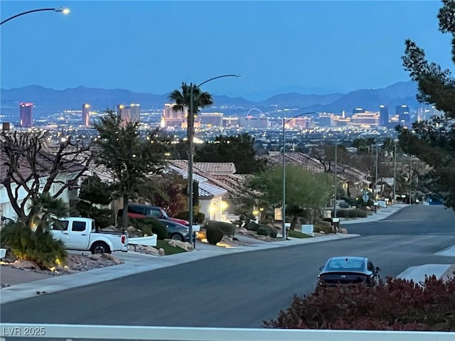 2736 Darby Falls Dr, Las Vegas, NV 89134 - view of asphalt road featuring a mountain view, street lighting, and a view of city