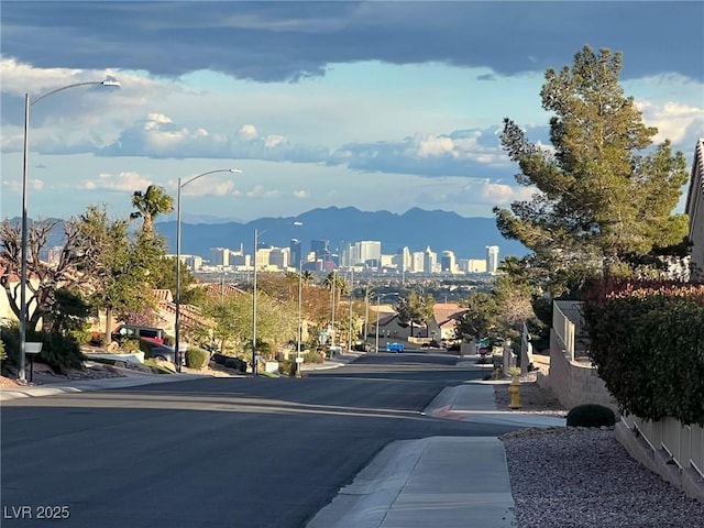2736 Darby Falls Dr, Las Vegas, NV 89134 - view of asphalt road with sidewalks, a mountain view, street lights, and a view of city
