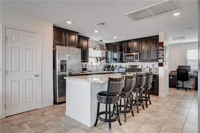 105 Campbelltown Ave, Henderson, NV 89015 - kitchen featuring a center island, appliances with stainless steel finishes, dark brown cabinetry, and visible vents