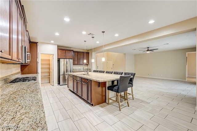 1004 Bluebird Ridge Ct, North Las Vegas, NV 89084 - kitchen with stainless steel appliances, a kitchen bar, light stone countertops, recessed lighting, and an island with sink