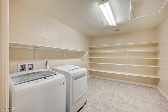 1004 Bluebird Ridge Ct, North Las Vegas, NV 89084 - laundry area with washing machine and clothes dryer, a textured ceiling, and light tile patterned floors
