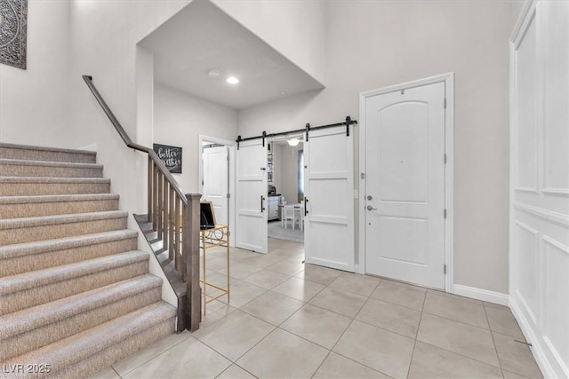 505 Punto Vallata Dr, Henderson, NV 89011 - entryway with light tile patterned floors, baseboards, a barn door, and stairway