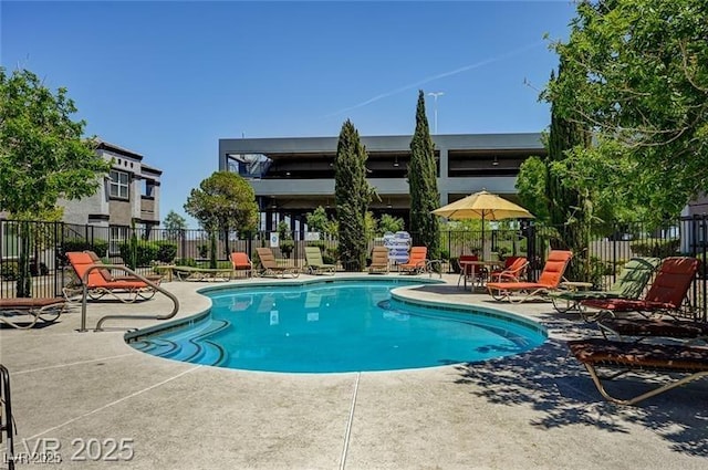 pool with a patio and fence