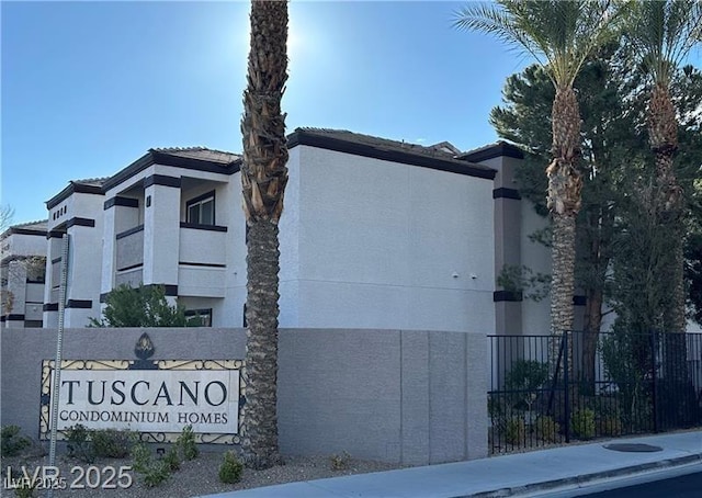 exterior space with stucco siding and fence