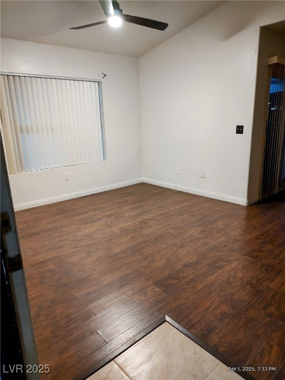 spare room with dark wood finished floors, baseboards, and a ceiling fan