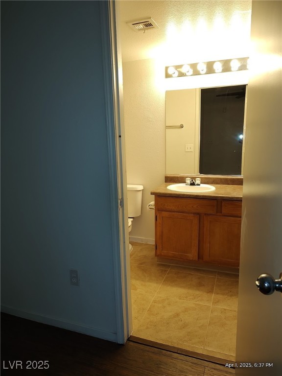 bathroom with toilet, tile patterned floors, vanity, and visible vents