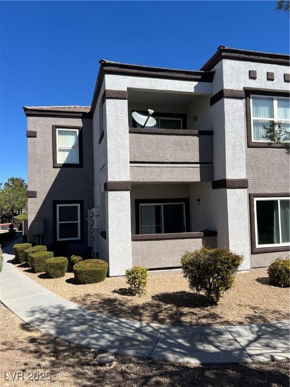 view of home's exterior with stucco siding and a balcony