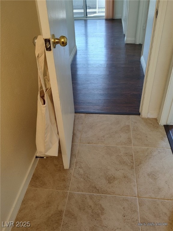 corridor featuring baseboards and wood finished floors