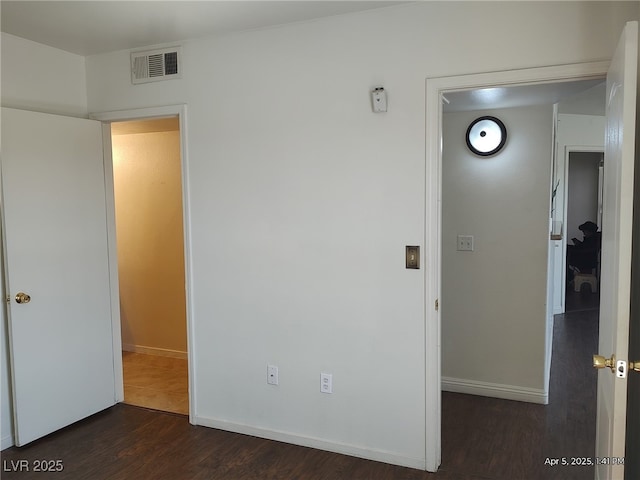 unfurnished bedroom featuring visible vents, baseboards, and dark wood finished floors