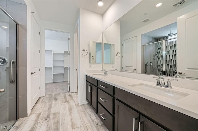 243 Sun Glaze Ave, Henderson, NV 89011 - full bathroom featuring a stall shower, double vanity, wood finished floors, a spacious closet, and recessed lighting