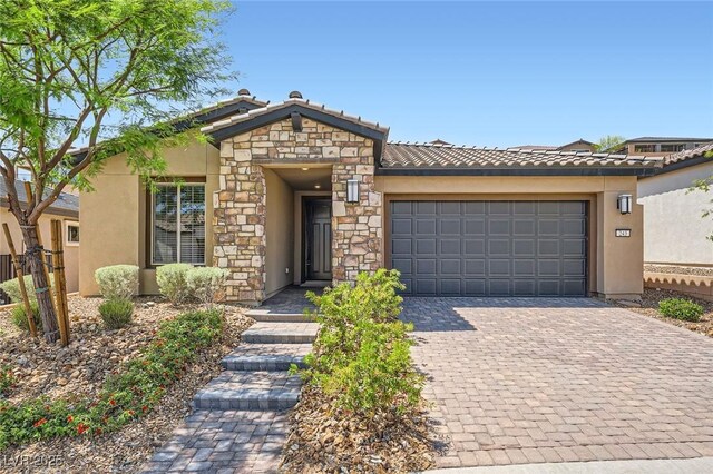 243 Sun Glaze Ave, Henderson, NV 89011 - view of front facade with an attached garage, decorative driveway, stucco siding, and a tiled roof
