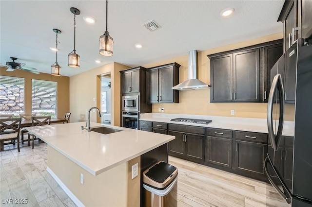 243 Sun Glaze Ave, Henderson, NV 89011 - kitchen with stainless steel appliances, wall chimney range hood, a sink, ceiling fan, and light countertops