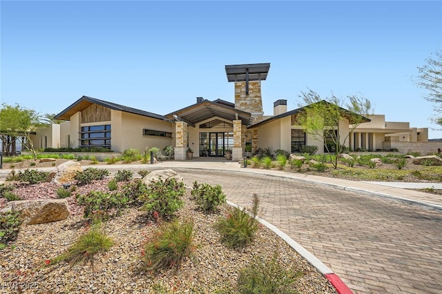 243 Sun Glaze Ave, Henderson, NV 89011 - view of front of home with a chimney, stucco siding, and stone siding