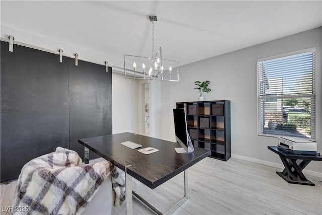 1609 Dream Canyon Ave, North Las Vegas, NV 89084 - home office featuring light wood-style flooring, baseboards, a notable chandelier, and a barn door