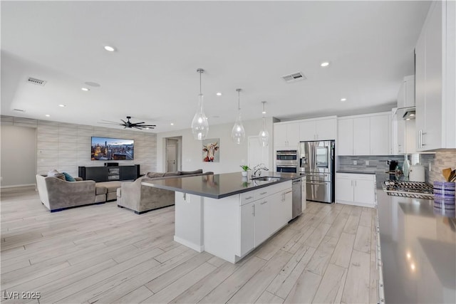 1609 Dream Canyon Ave, North Las Vegas, NV 89084 - kitchen with dark countertops, a ceiling fan, light wood-style flooring, appliances with stainless steel finishes, and visible vents