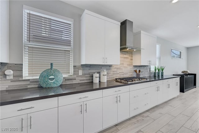 1609 Dream Canyon Ave, North Las Vegas, NV 89084 - kitchen featuring dark countertops, stainless steel gas cooktop, tasteful backsplash, and wall chimney range hood