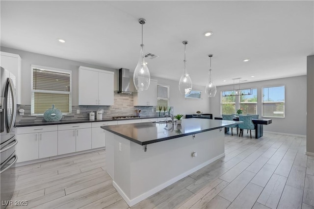 1609 Dream Canyon Ave, North Las Vegas, NV 89084 - kitchen featuring stainless steel appliances, dark countertops, visible vents, white cabinetry, and wall chimney range hood