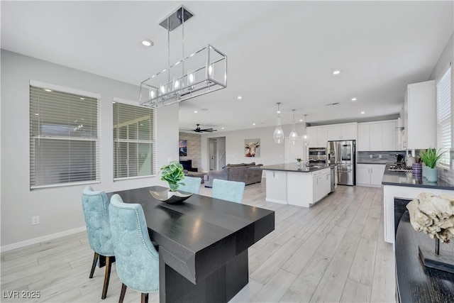 1609 Dream Canyon Ave, North Las Vegas, NV 89084 - dining area featuring a ceiling fan, light wood-type flooring, a fireplace, baseboards, and recessed lighting