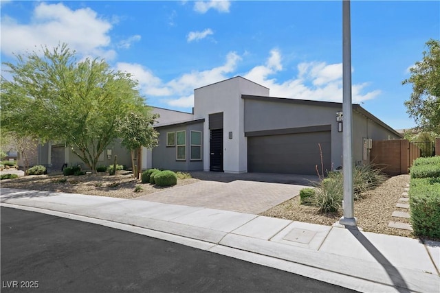 1609 Dream Canyon Ave, North Las Vegas, NV 89084 - modern home with an attached garage, fence, decorative driveway, and stucco siding