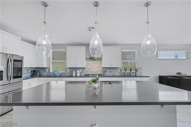 1609 Dream Canyon Ave, North Las Vegas, NV 89084 - kitchen featuring white cabinets, dark countertops, visible vents, decorative backsplash, and appliances with stainless steel finishes