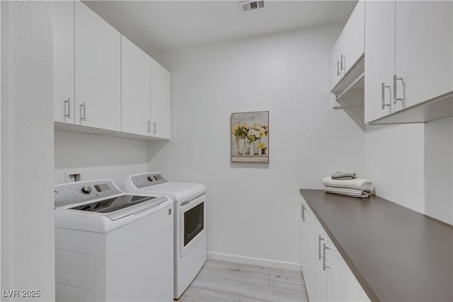1609 Dream Canyon Ave, North Las Vegas, NV 89084 - laundry area featuring washing machine and clothes dryer, light wood-type flooring, cabinet space, baseboards, and visible vents