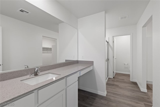full bathroom with baseboards, visible vents, wood finished floors, and vanity