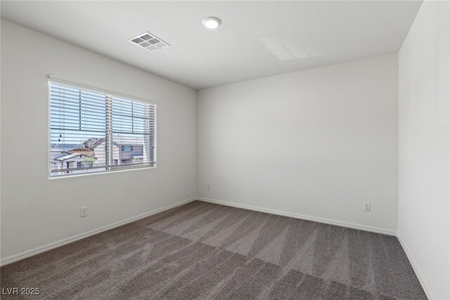 carpeted spare room featuring baseboards and visible vents