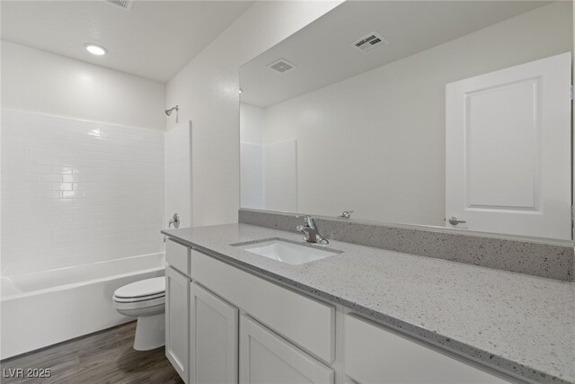 full bathroom featuring vanity, toilet, tub / shower combination, visible vents, and wood finished floors