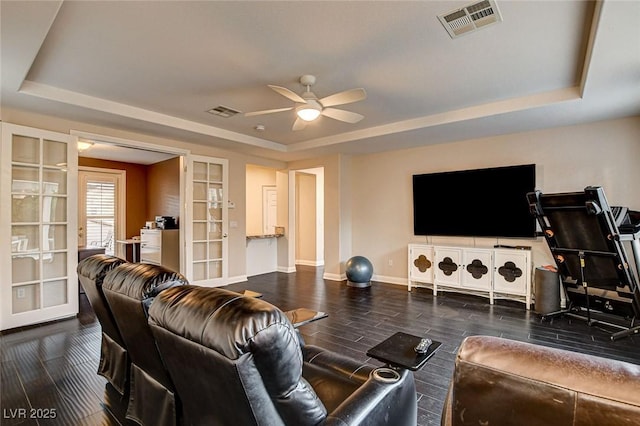 living area featuring visible vents, wood finished floors, a raised ceiling, french doors, and a ceiling fan