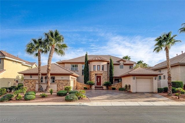 view of front facade with an attached garage, stucco siding, driveway, and stone siding